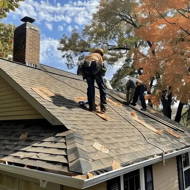 Roofing professionals working on a shingle roof